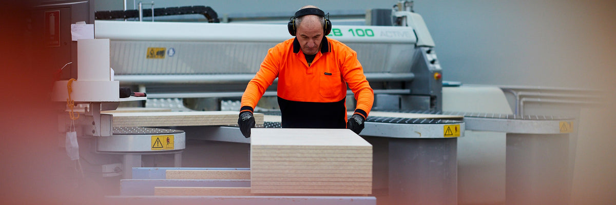 Medium shot of a beam saw operator organising cut to size particle board panels in a Melbourne warehouse