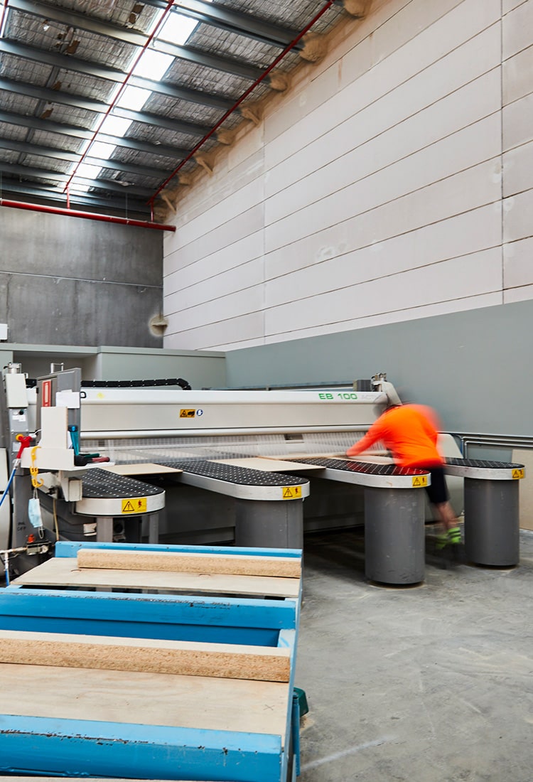 Particle board panels being loaded into an industrial beam saw to be cut to size at Plyco Mornington